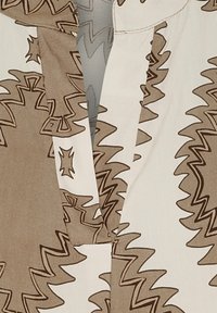 Brunt og kremfarvet mønstret stof med zigzag- og stjernemotiver, der har et opdelt design og en glat tekstur. Strukturering af kraven er inkluderet.