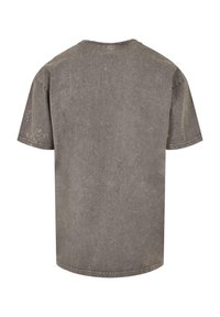 Grå kortærmet T-shirt lavet af tekstureret stof. Har en rund halsudskæring, afslappet pasform og slidte detaljer overalt.