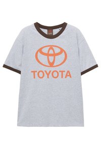 Sivé bavlnené tričko s hnedými lemami na krku a rukávoch, s oranžovým logom Toyota a textom "TOYOTA" umiestneným pod logom v strede.