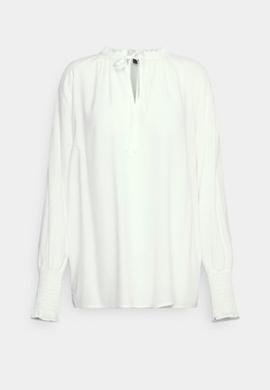 Blusa branca de mangas longas com decote franzido, fecho de laço e punhos com elástico. Tecido suave com um corte solto e design minimalista.