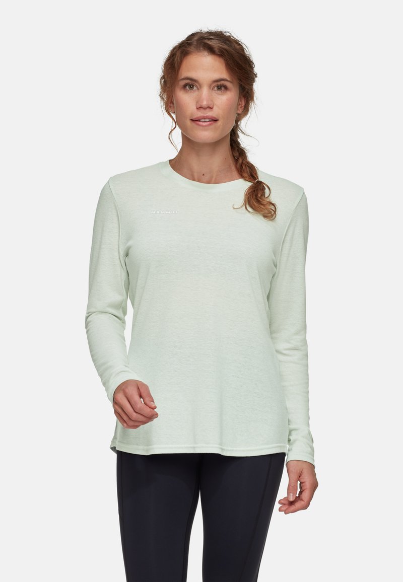 Jasno miętowa koszula z długim rękawem, miękka w dotyku, z dekoltem w kształcie zaokrąglenia, z małym detalem logo z przodu, w połączeniu z ciemnymi, dopasowanymi spodniami.