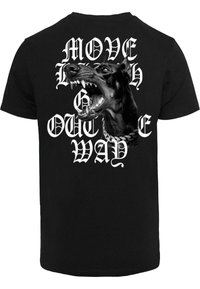 Sort t-shirt med et stort grafisk design af et gøende hundehoved med hvid tekst "MOVE OUT THE WAY" i fede, stiliserede skrifttyper.