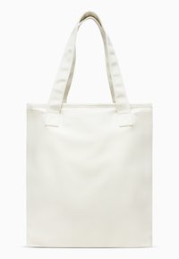 Canvas tote bag in off-white, featuring two sturdy handles and a structured rectangular shape. Surface is smooth with a subtle texture.