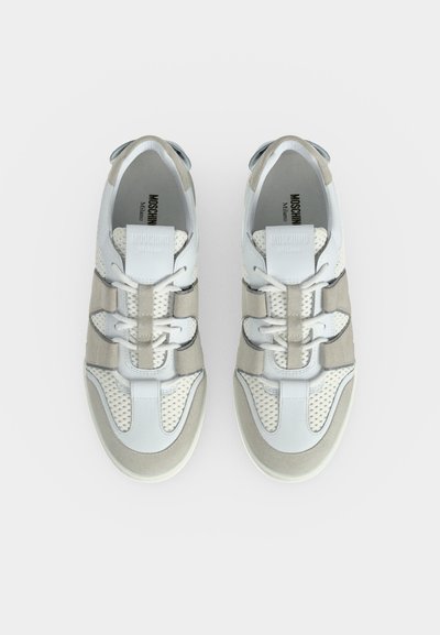 Ζευγάρι λευκά και μπεζ sneakers Moschino Milano με πλέγμα και δέσιμο με κορδόνια, από ψηλά σε λευκό φόντο.