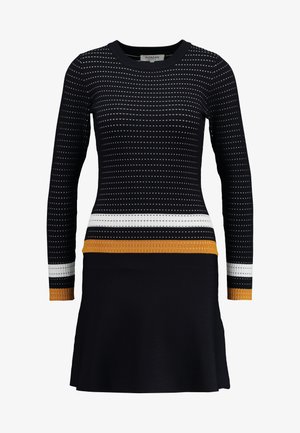Zwarte gebreide jurk met lange mouwen, een ronde halslijn en horizontale strepen in wit en goud op de taille en mouwen, met een uitlopende rok.