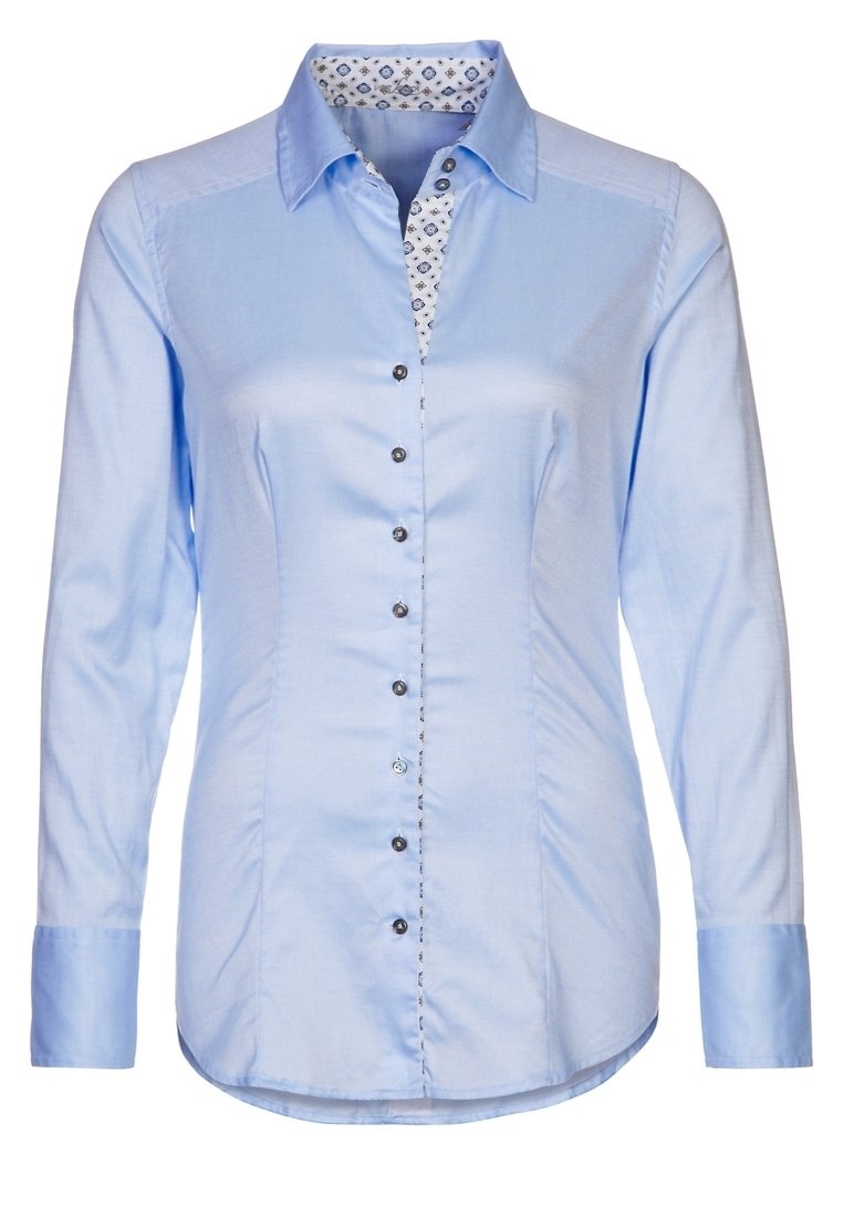 Ljust blå skjorta med lång ärm, med ett mönstrat kragefoder. Svarta knappar längs fram. Slät tygtextur.