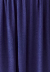 Morski plavi zastor izrađen od teksturiranog materijala s blagim sjajem; ima nabrane nabore na vrhu, što daje mekan i tečan izgled.