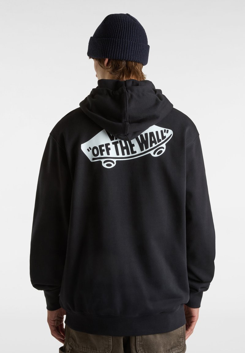 Sweat à capuche noir avec un grand graphisme blanc "OFF THE WALL" dans le dos. Il présente une coupe décontractée, des poignets côtelés et une capuche spacieuse.