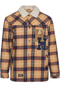 Plaid jacket in tan, navy, and burgundy. Features a sherpa collar, button closure, and an embroidered logo on the chest.