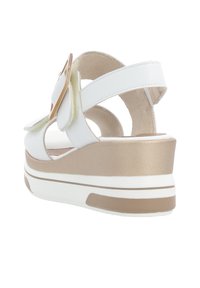 Sandale compensée blanche avec une large sangle et une boucle dorée, semelle intérieure douce texturée et semelle de plateforme contrastante beige clair.