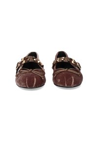 Mocasines de terciopelo marrón con detalles decorativos de cadena dorada y lazos en la parte delantera. Diseño de punta redondeada con una textura suave.