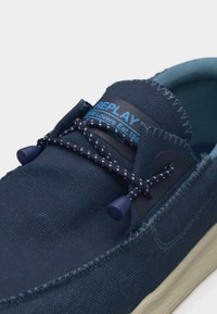 Pantof casual din material bleumarin cu talpă bej, șireturi elastice bungee cu capete din plastic și branding „REPLAY” pe eticheta limbii.