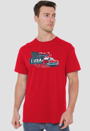 Red cotton t-shirt featuring a graphic design of a vintage Chevrolet car with an American flag background and text "1 USA - Chevrolet."