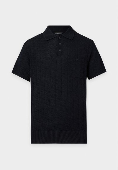Polo noir en maille à manches courtes avec motif texturé, patte de boutonnage trois boutons, col et ourlet côtelés, et une petite poche poitrine avec bouton.