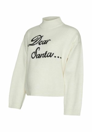 Cream-colored knit sweater featuring a mock turtleneck, dropped shoulders, and black text reading "Dear Santa..." across the front.