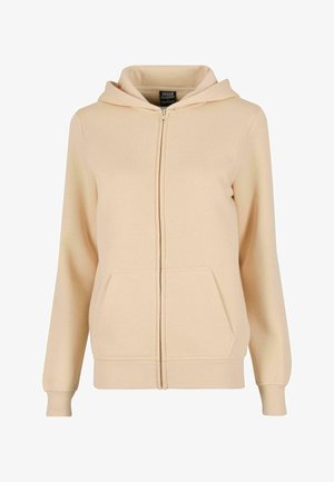 Šviesiai rudas užtraukiamas džemperis, pagamintas iš minkštos medžiagos, su priekinėmis kišenėmis, raukšlėtomis rankogaliais ir su raišteliu reguliuojama kapuce. Paprastas dizainas be raštų.