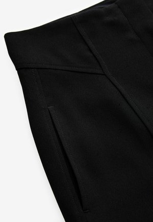 Zwarte op maat gemaakte broek met een stijlvolle textuur, voorzien van gestikte naden en schuin geplaatste zakken. De stof lijkt lichtgewicht en gestructureerd.