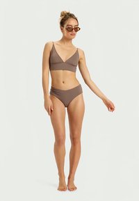 Brown bikini set features a triangular bralette and high-waisted bottoms. The fabric has a smooth texture and minimal detailing.