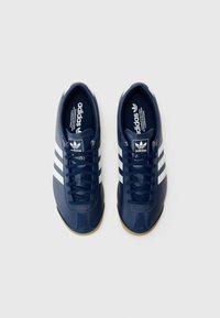 Mørkeblå sneakers med tre hvide striber, lædermateriale, rund tå, gummisåler og mærketuning detalje. Snørebåndsdesign.