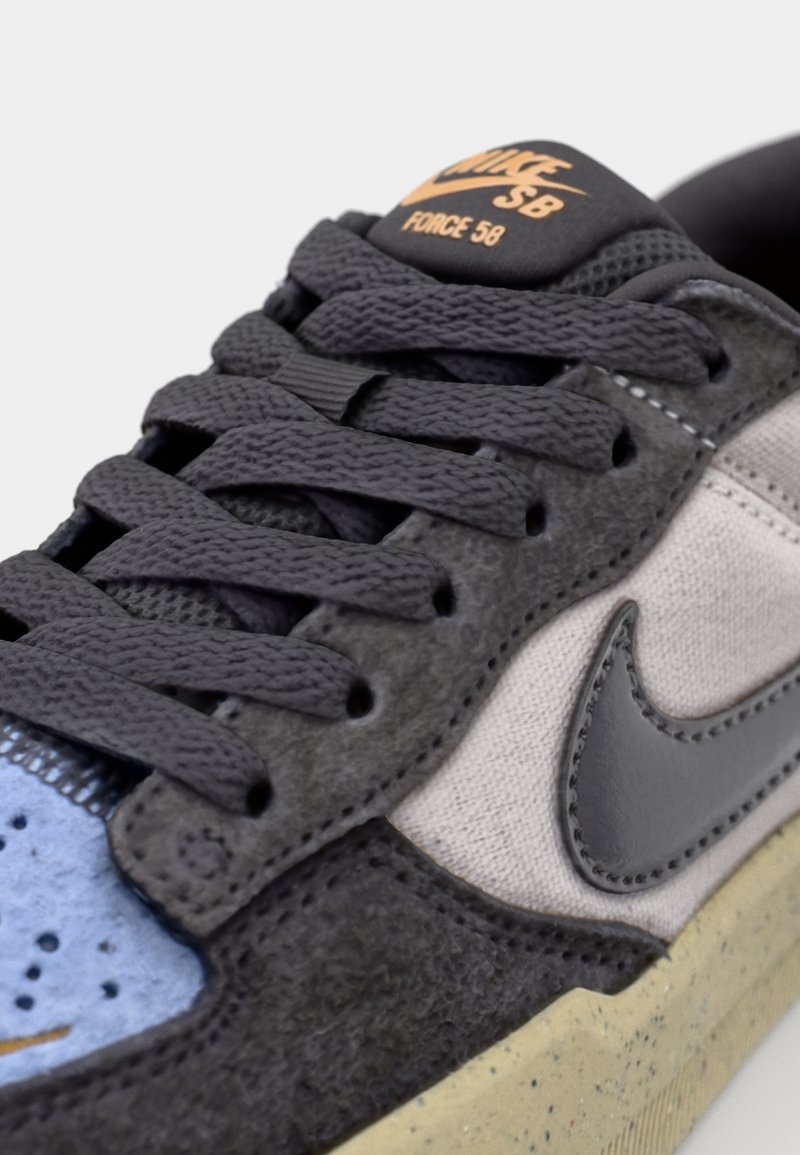 Czarno-szare sneakersy z zamszu i tkaniny z niebieskimi akcentami, płaskimi sznurowadłami i gumową podeszwą. Logo "NIKE SB FORCE 58" na języku.