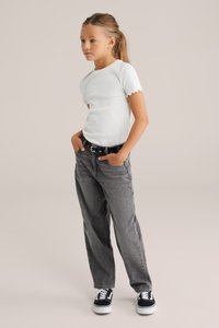 Valge ribaga T-särk laineliste varrukatega, millele on lisatud laiad hallid teksad ja mustad tossud valgete tallade ja paeltega.