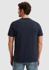 Marineblauwe katoenen t-shirt met korte mouwen, ronde halslijn en een soepele textuur. Van achteraf weergegeven, met een eenvoudig ontwerp.
