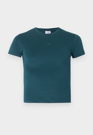 Camiseta de manga corta y cuello redondo en color verde azulado oscuro, con un pequeño logo sutil en el pecho, mostrada sobre un fondo claro y sencillo.