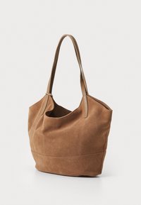 Bolso de tote de ante marrón con dos asas de cuero, textura suave, gran abertura y base estructurada. Presenta costuras reforzadas en las costuras.