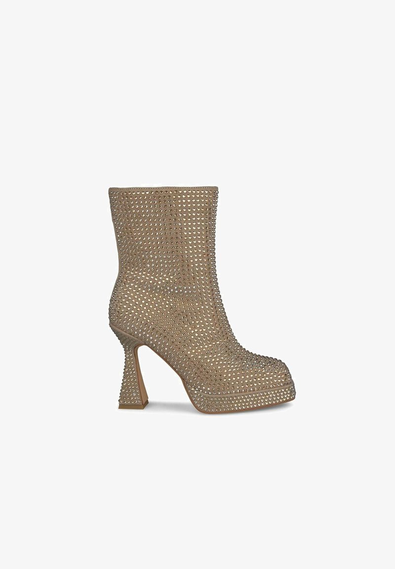 Beige kotníková bota s kovovými nýty, kulatou špičkou a masivním podpatkem. Hladký povrch s texturovaným vzorem po celé ploše.
