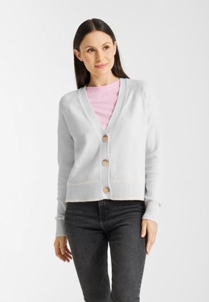 Lichtgrijze cardigan met een V-hals, vier ronde knopen en geribde boorden en cuffs. Draag het over een roze shirt en combineer het met donkere jeans.