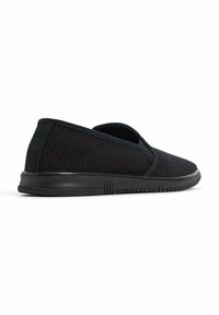 Czarne siateczkowe buty wsuwane z teksturowaną cholewką, miękką wyściółką i gumową podeszwą z umiarkowanym wzorem bieżnika. Niska krawędź projektu.