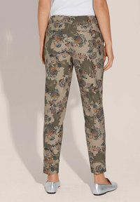 Blumenmuster-Hosen in Olivgrün und Beige, aus einem weichen Stoff gefertigt. Sie verfügen über eine schlanke Passform mit schmal zulaufendem Bein und Rückentaschen.