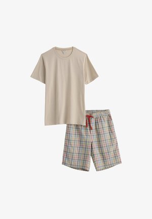 Bež majica kratkih rukava s okruglim izrezom u kombinaciji s višebojnim kariranim šorcem do koljena s crvenim nogicama u struku.