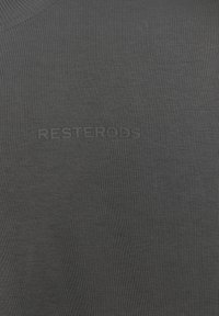 Dark gray knitted fabric with vertical stripes, featuring the embossed text "RESTERÖDS" in a central position. Smooth texture.
