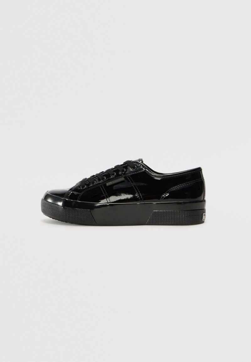 Black patent leather sneakers with a rounded toe, thick textured sole, and black laces. Features subtle stitching and a sleek finish.