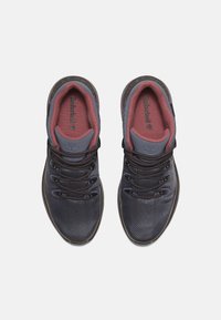 Zapatillas de malla marinas con acentos grises, forro textil y suela de goma negra. Presentan cordones resistentes y un logotipo de la marca destacado en la lengua.