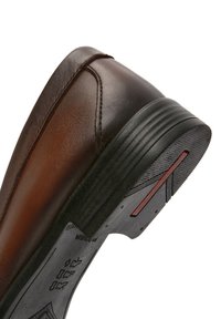 Bruine leren schoen met een ronde neus, gestikte accenten en een gestructureerde zwarte rubberen zool met rode details op de hak.