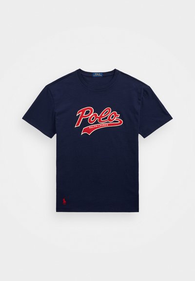 Námořnická modrá bavlněná tričko s velkým červeným logem "Polo" s bílými akcenty, krátkými rukávy a malým červeným logem na dolním levém rohu.