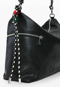 Must nahast kott nurkadega, millel on külgsulgur, punase, rohelise ja musta tooniga punutud rihm ning hõbedased riistvara detailid.