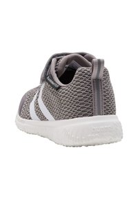 Leichter grauer Sneaker mit einem strukturierten Mesh-Obermaterial, weißen Akzenten und einer Gummisohle. Verfügt über eine Zuglasche für einfaches An- und Ausziehen.