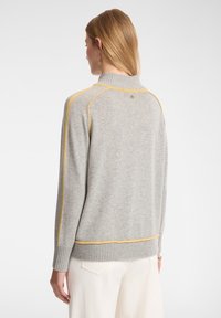 Hellgrauer Pullover mit gelben Akzenten an den Schultern und dem Saum, gerippte Bündchen und Kragen, lässige Passform, weiche Textur.