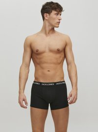 Schwarze Boxershorts mit einem schwarzen Bund, der das weiße "JACK & JONES"-Logo trägt. Hergestellt aus glattem Stoff, angepasstes Design, mittellange Beinlänge.