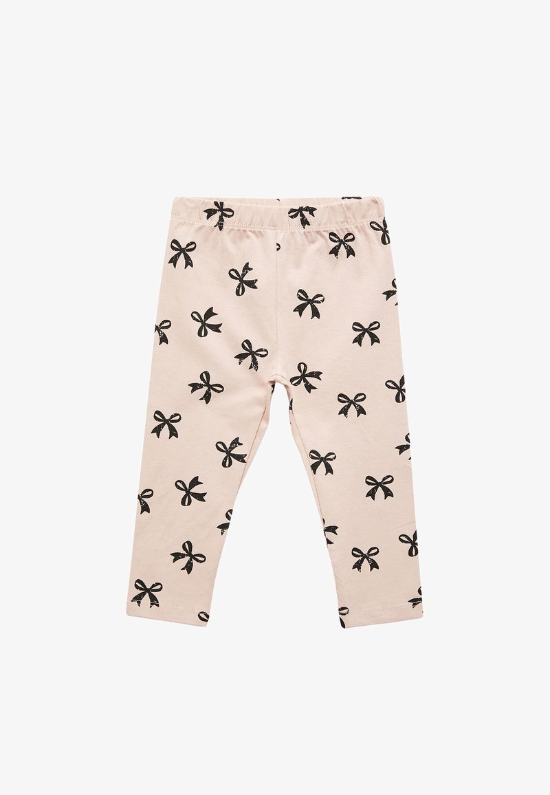 Leggings rose clair en coton, avec un motif de nœuds noirs répété, une taille élastique et une coupe ajustée.