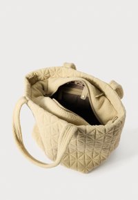 Sac fourre-tout beige matelassé avec deux poignées et une poche intérieure zippée. Texture douce avec un motif triangulaire ; intérieur doublé d'un matériau plus foncé.