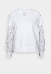 Vit sweatshirt med långa, puffiga ärmar med intrikata utskärningsmönster. Slät textur med rundad halsringning och ribbade manschetter.