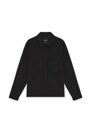 Chemise noire à manches longues avec boutons, col et une poche poitrine zippée sur le côté gauche, posée à plat sur un fond blanc.