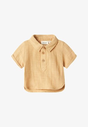 Camicia a maniche corte, a collo, in lino beige chiaro, con tre bottoni rotondi e una finitura testurizzata. Presenta un orlo curvo e un'etichetta sul petto.