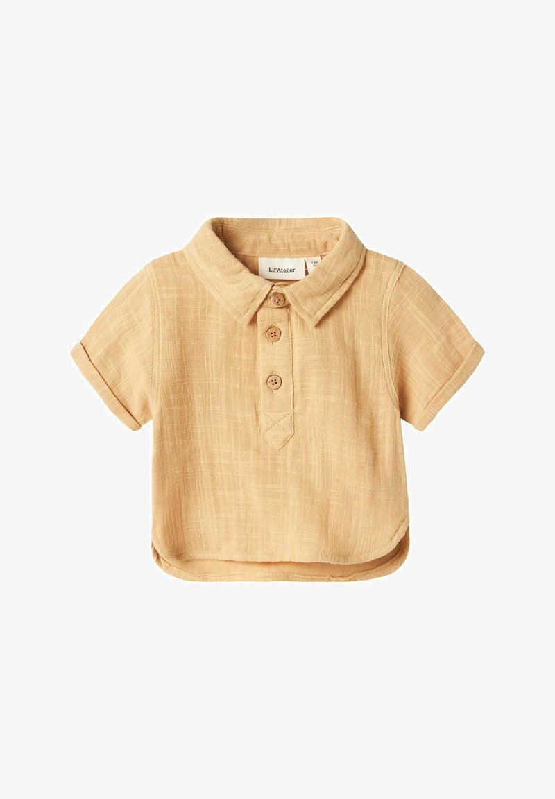 Camicia a maniche corte, a collo, in lino beige chiaro, con tre bottoni rotondi e una finitura testurizzata. Presenta un orlo curvo e un'etichetta sul petto.