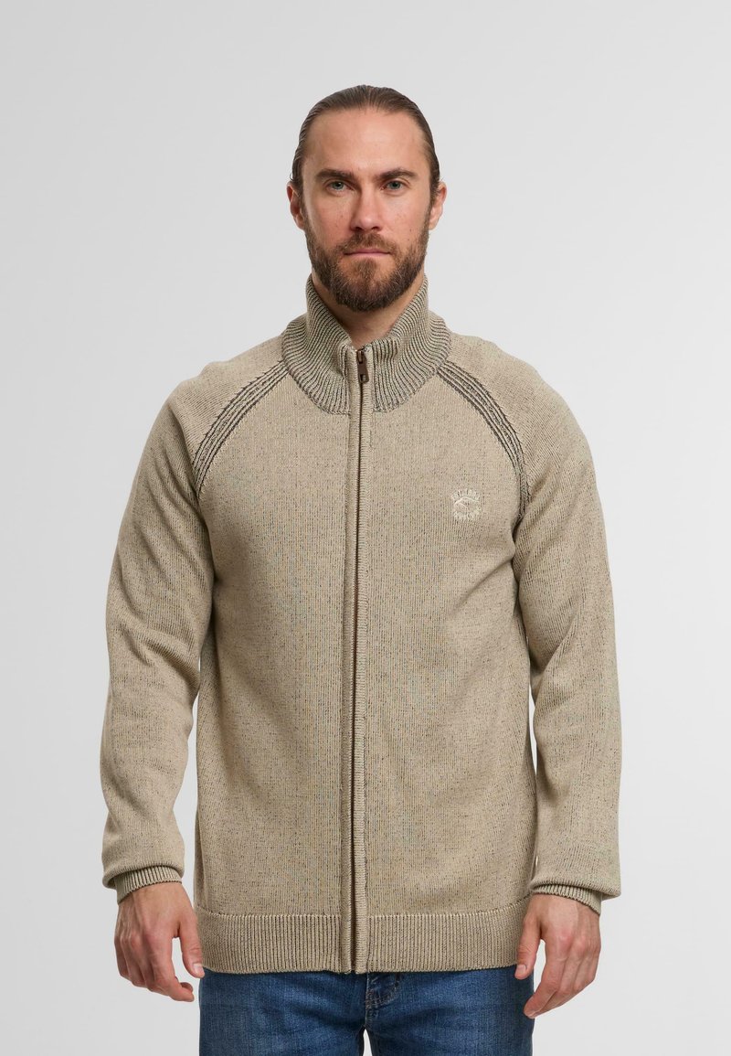 Trui met ritssluiting in beige met een gestructureerde afwerking, verhoogde kraag en contrasterende schoudernaden. Voorzien van geborduurd logo op de borst.