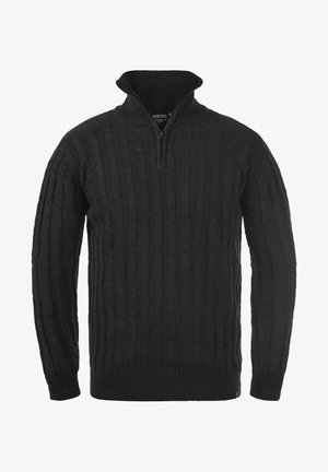 Juoda megzta megztinė su aukštu apykakle ir užtrauktuku. Audinys yra storas, su raukšlėmis ant rankovių ir apatinio krašto.